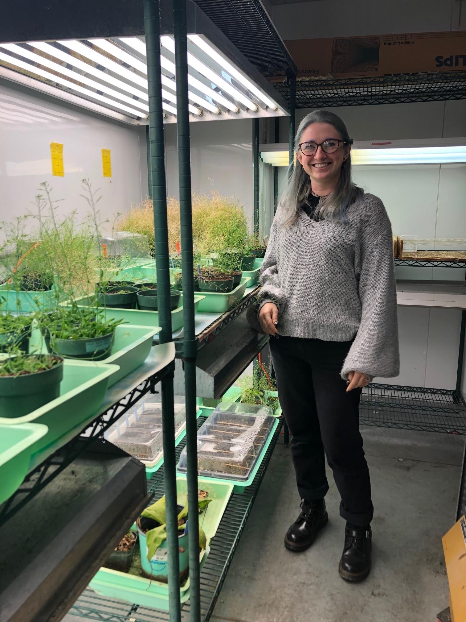 Erika Haws standing by research plants